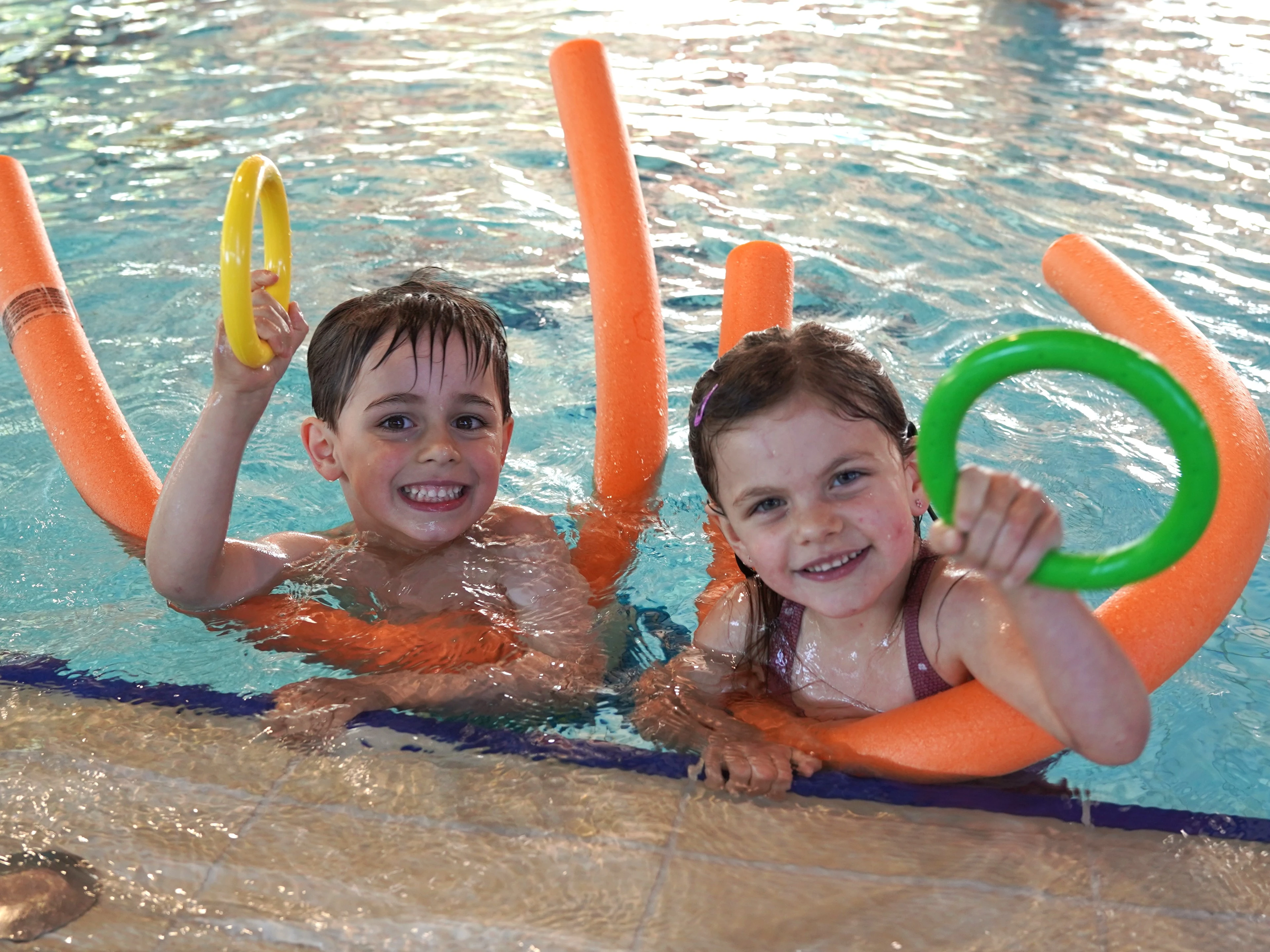 Zwei Kinder mit Schwimmringen im Becken – Swimgood Schwimmschule